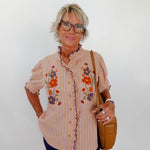 Woman wearing a floral blouse with a plain background