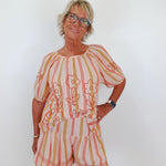 Woman wearing a striped outfit with a white background
