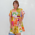 Woman wearing a colorful patterned dress with a white background