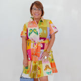 Woman wearing a colorful patterned dress with a white background