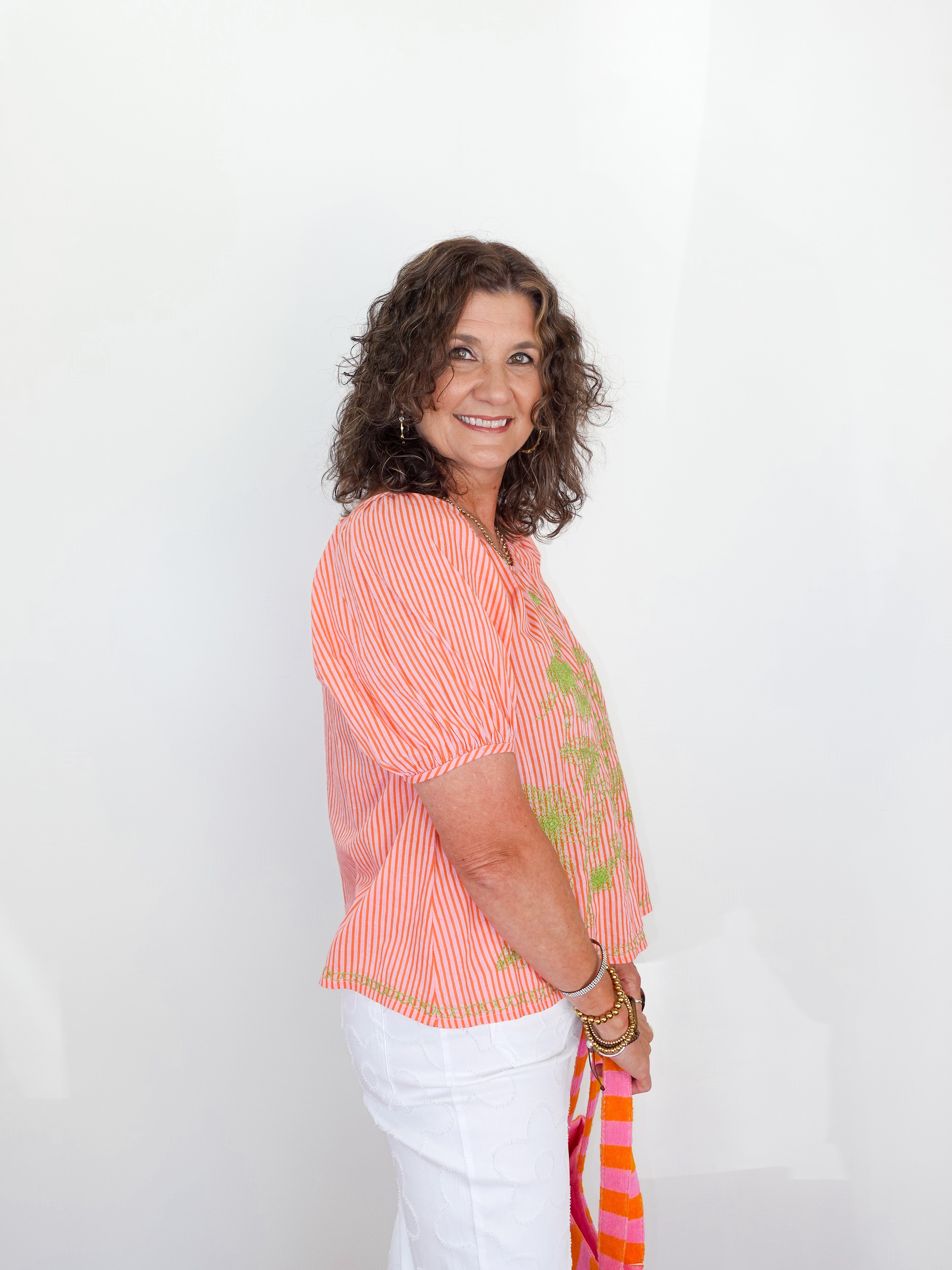 Woman wearing a colorful striped shirt with a white background