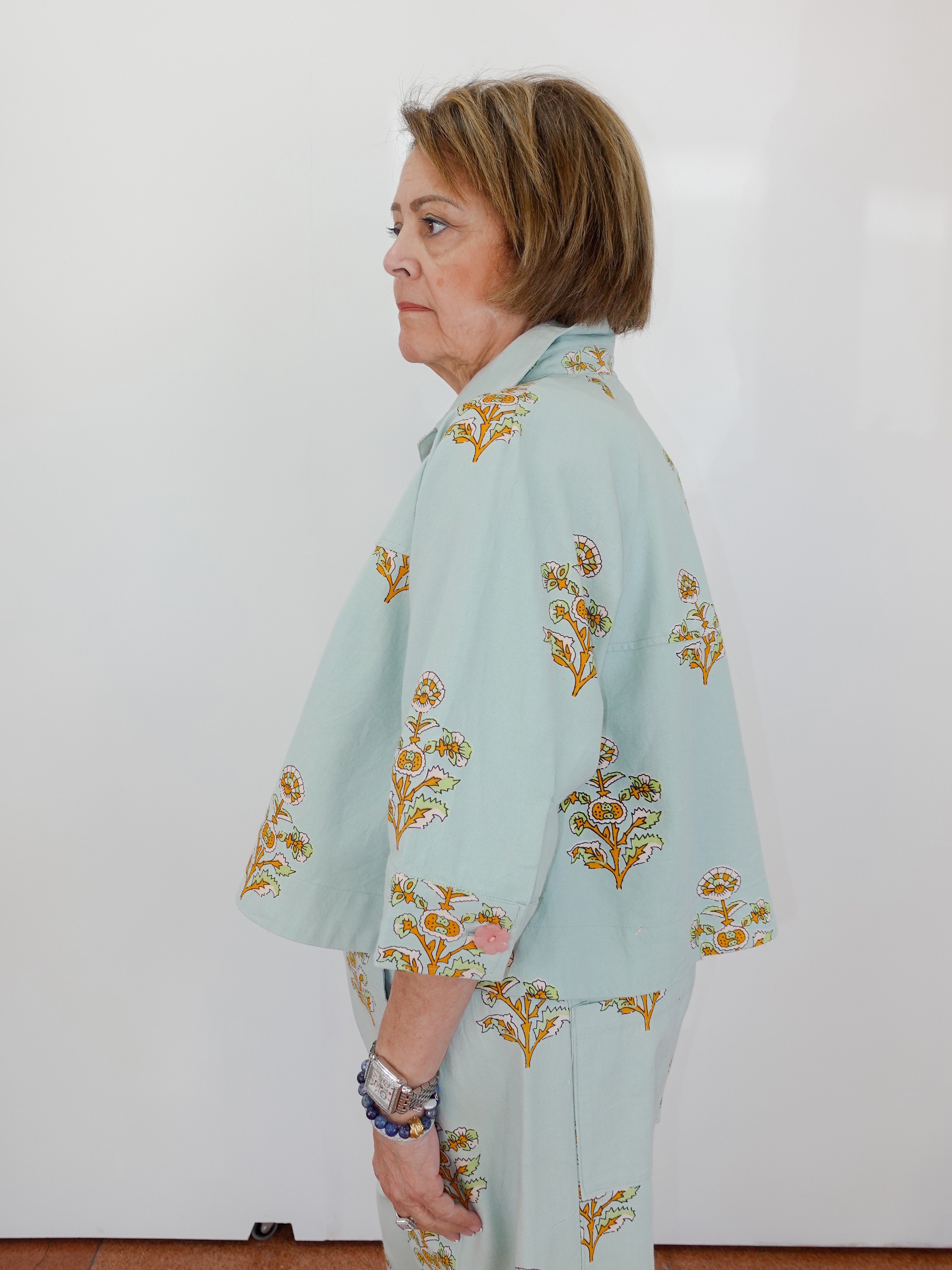 Woman wearing a light blue floral outfit against a white background