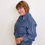 Woman wearing a denim jacket and jeans against a white background