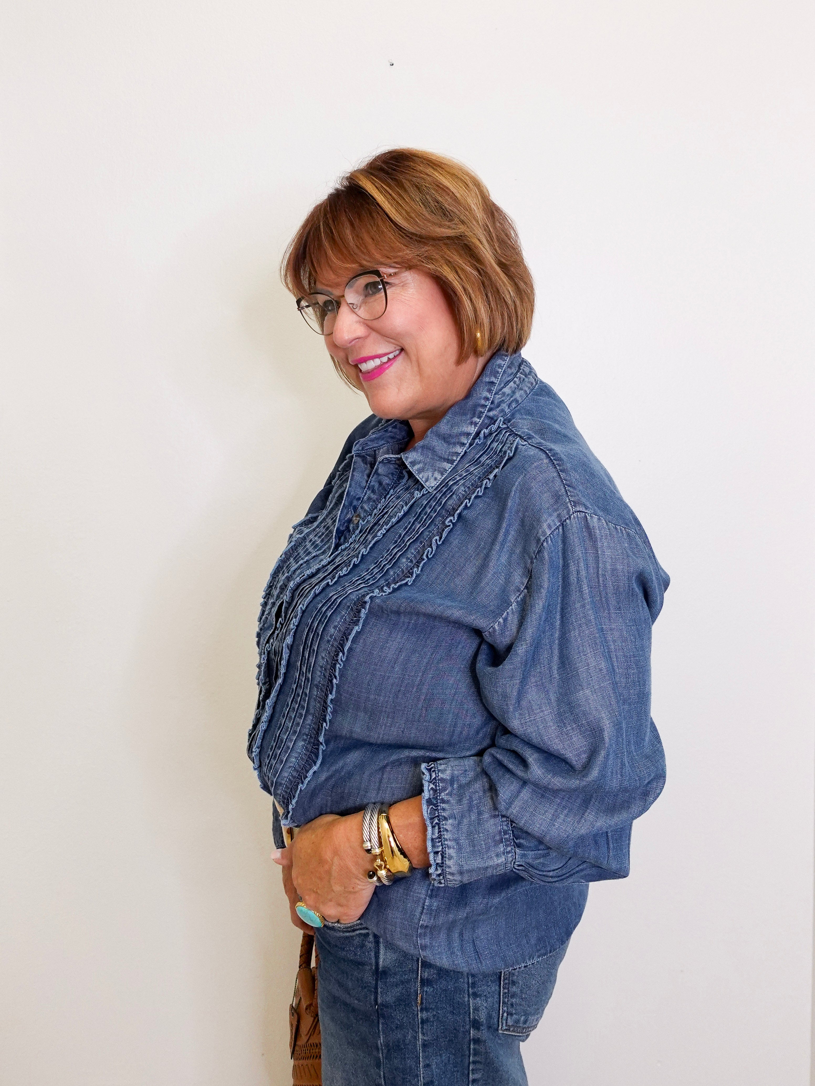 Woman wearing a denim jacket and jeans against a white background