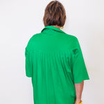 Person wearing a green shirt against a white background
