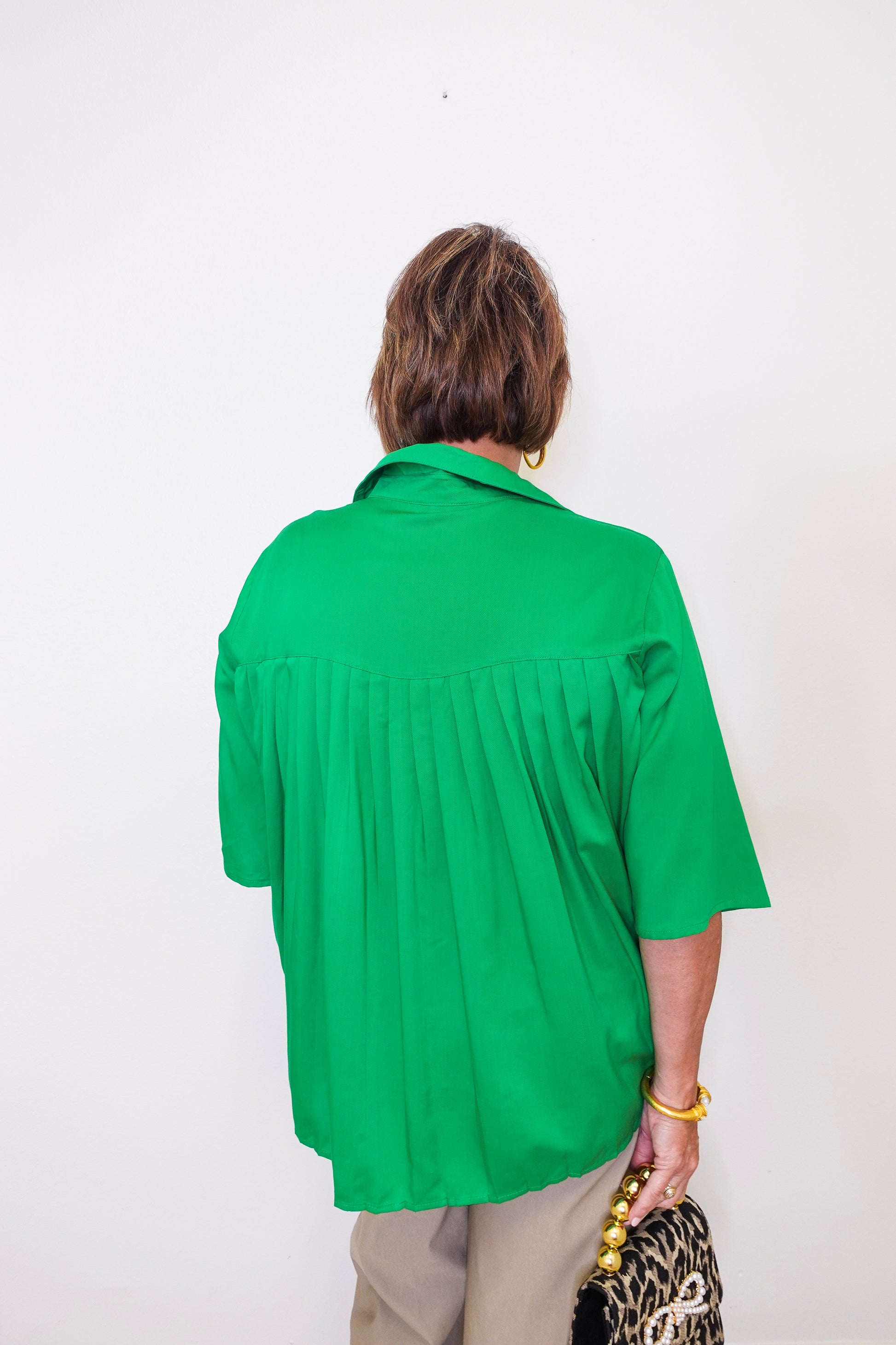 Person wearing a green shirt against a white background