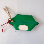 Green hexagonal pouch with a gold zipper and red string on a white background