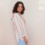 Woman wearing a colorful striped shirt against a plain background