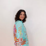 Woman wearing a colorful floral-patterned jacket against a white background