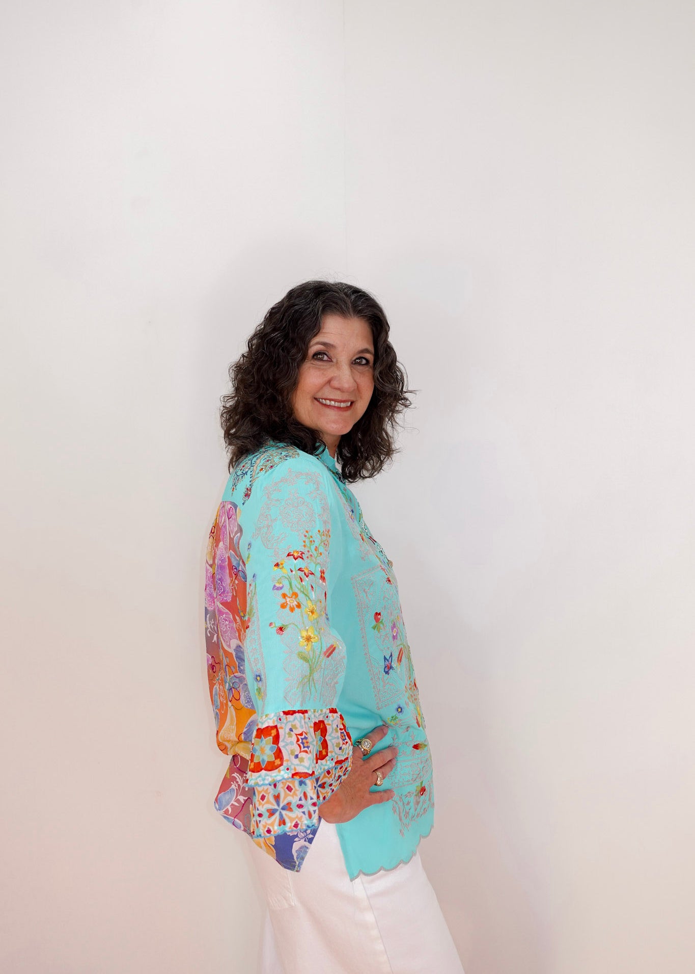 Woman wearing a colorful floral-patterned jacket against a white background