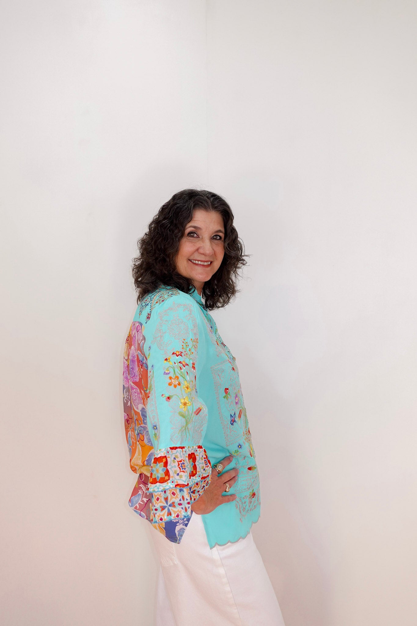 Woman wearing a colorful floral-patterned jacket against a white background