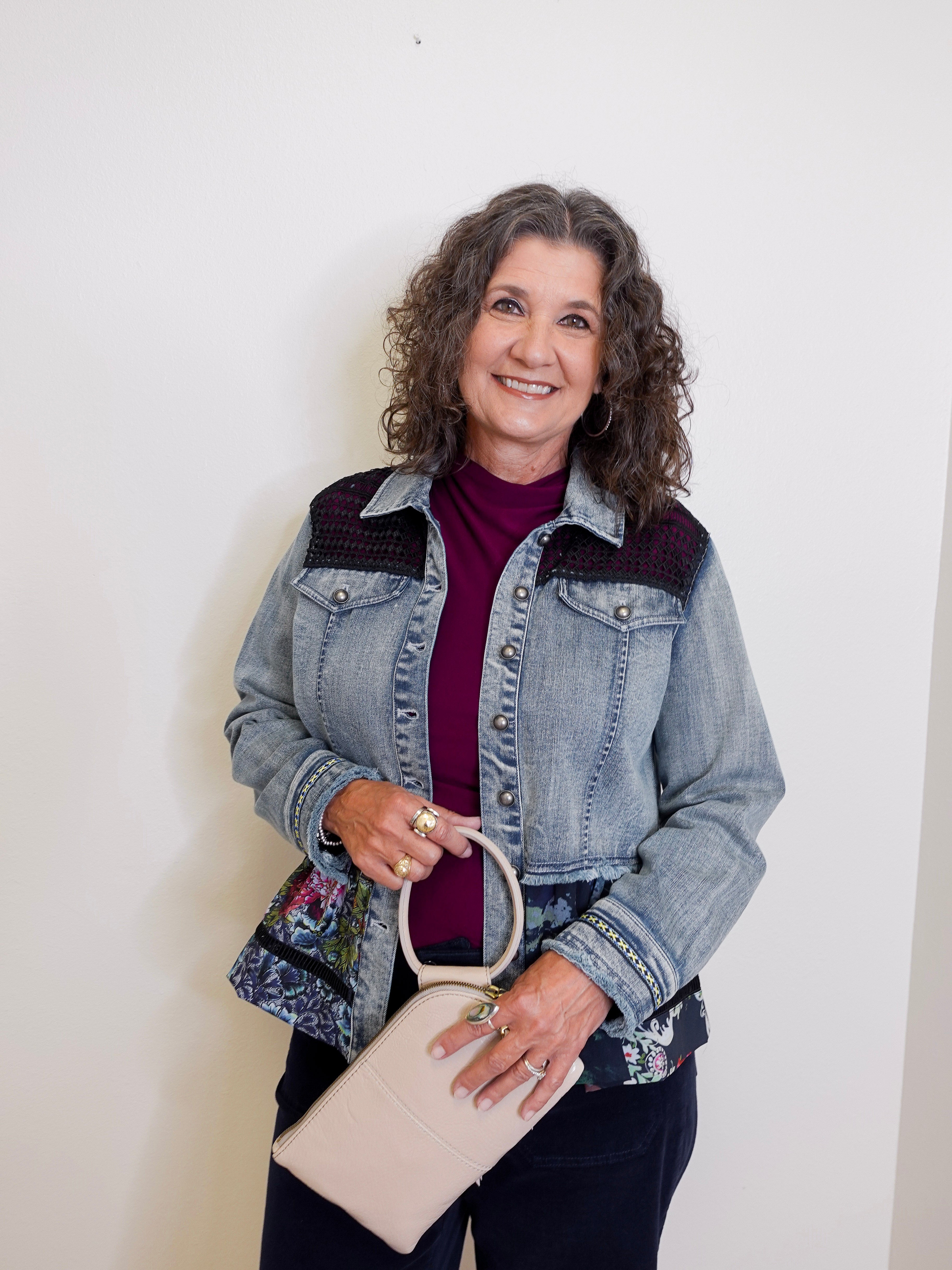 Woman holding a beige handbag against a white background