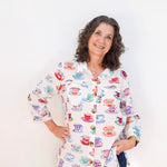 Woman wearing a colorful shirt with tea cup pattern against a white background
