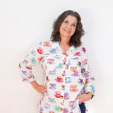 Woman wearing a colorful shirt with tea cup pattern against a white background