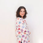 Woman wearing a colorful patterned shirt against a white background