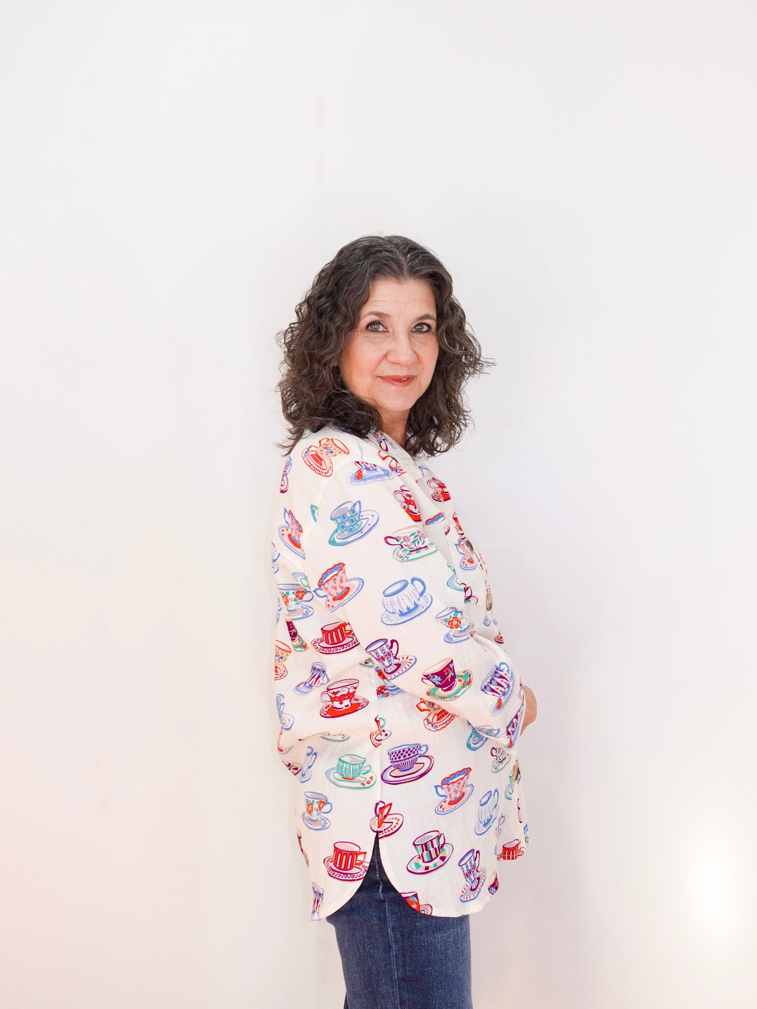 Woman wearing a colorful patterned shirt against a white background