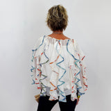 Person wearing a colorful blouse with a white background