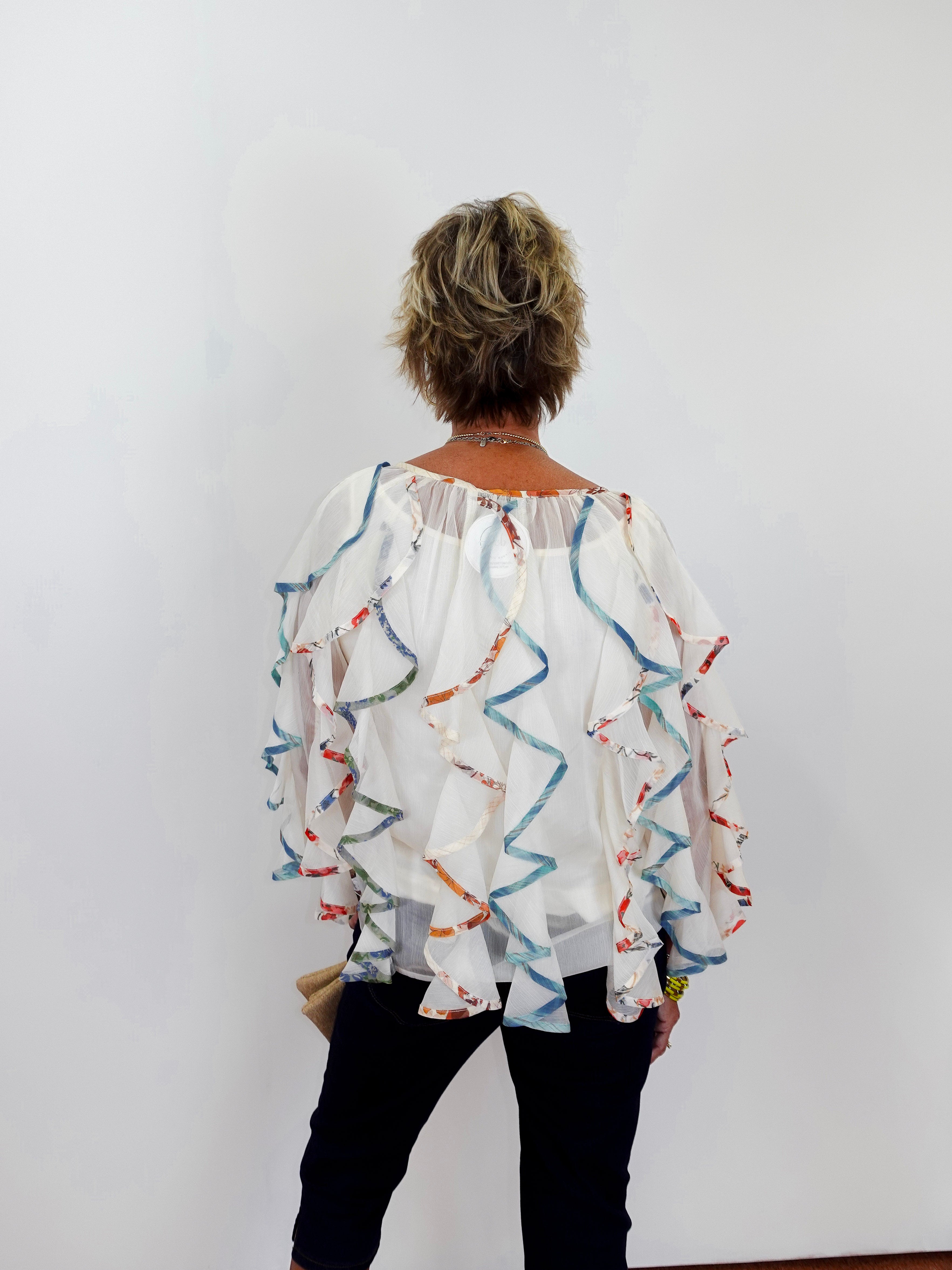 Person wearing a colorful blouse with a white background