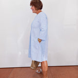 Woman wearing a light blue dress with a white background