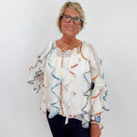 Woman wearing a patterned blouse with a plain background