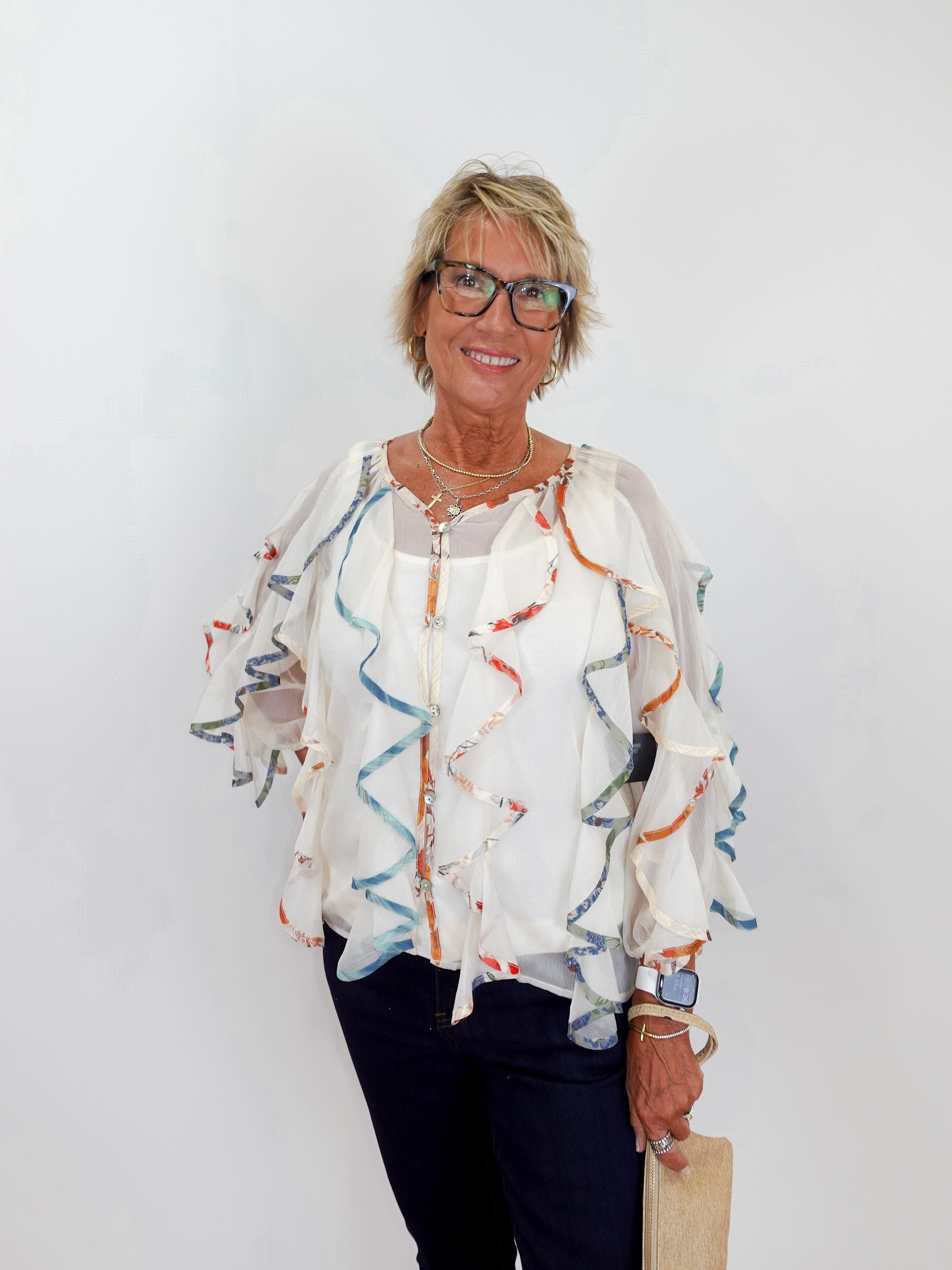 Woman wearing a patterned blouse with a plain background