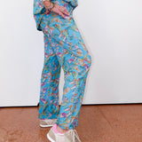 Person wearing a blue floral patterned outfit on a plain background