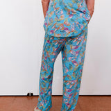 Person wearing a blue floral patterned outfit on a plain background