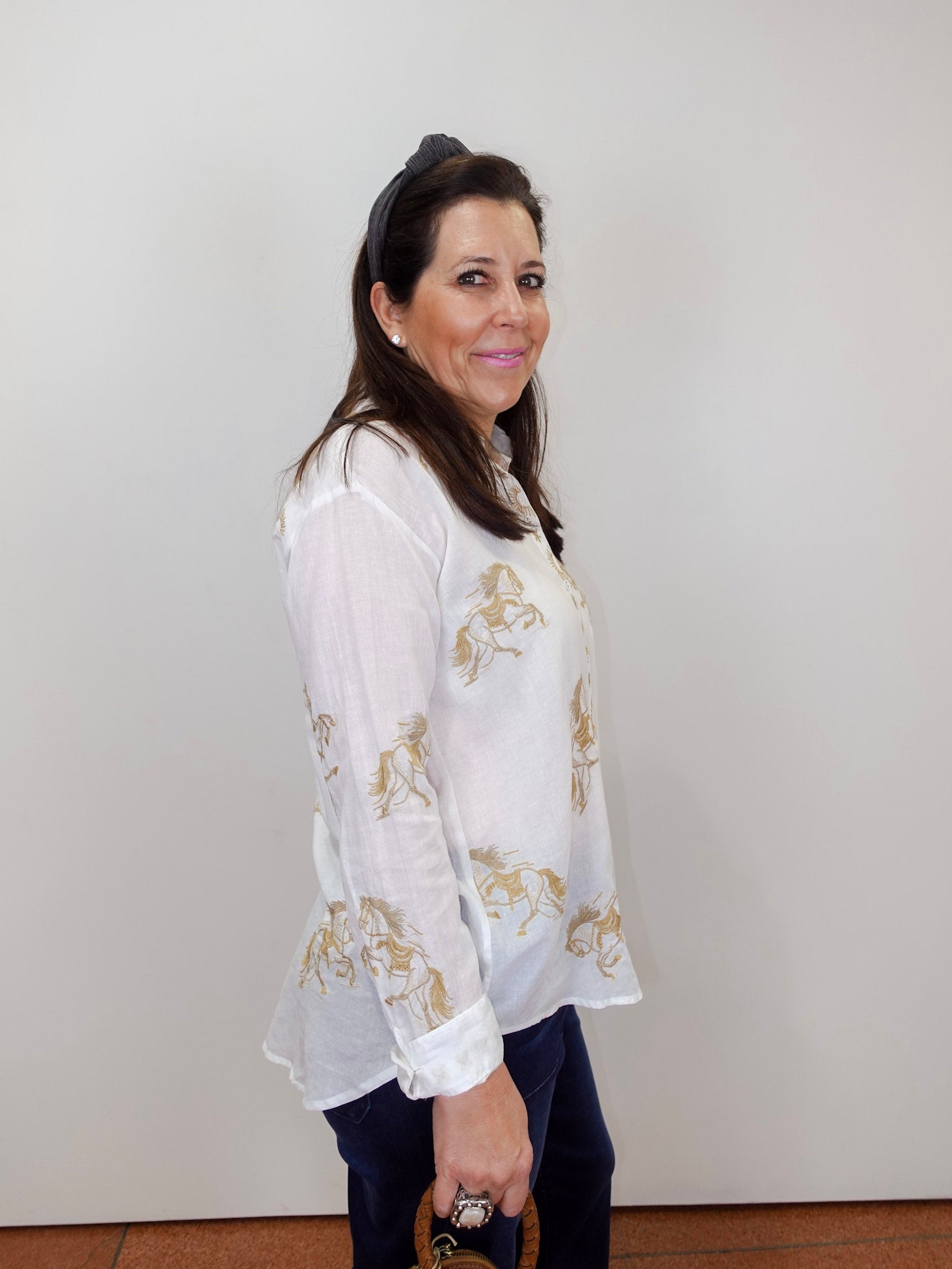 Model wearing the Johnny Was Cheval oversized shirt in white with gold horse print and button-front design.