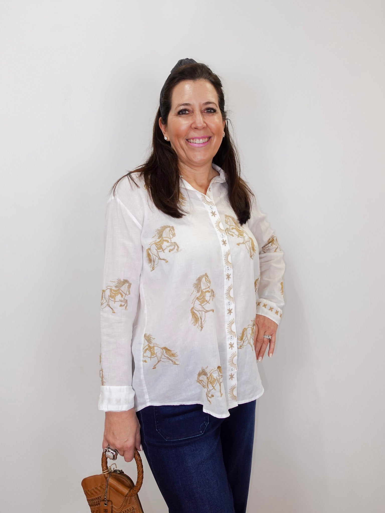 Model wearing the Johnny Was Cheval oversized shirt in white with gold horse print and button-front design.