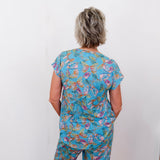 Person wearing a blue floral patterned outfit against a white background