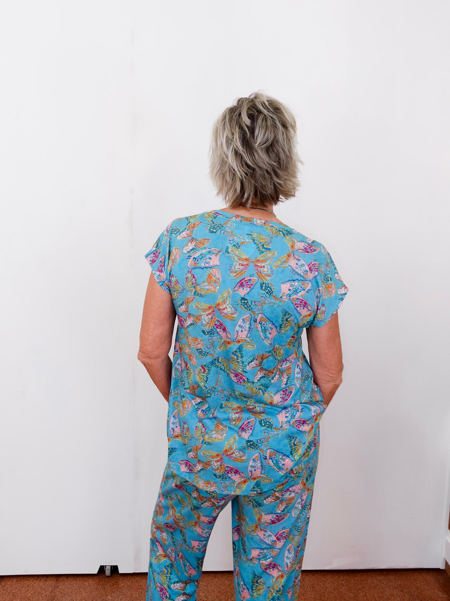 Person wearing a blue floral patterned outfit against a white background
