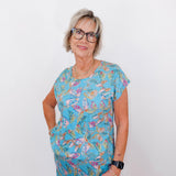 Woman wearing a colorful patterned outfit against a white background