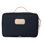 Black toiletry bag with beige handle and patch on a white background