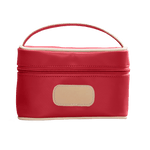 Red cosmetic bag with beige handle and patch on a black background