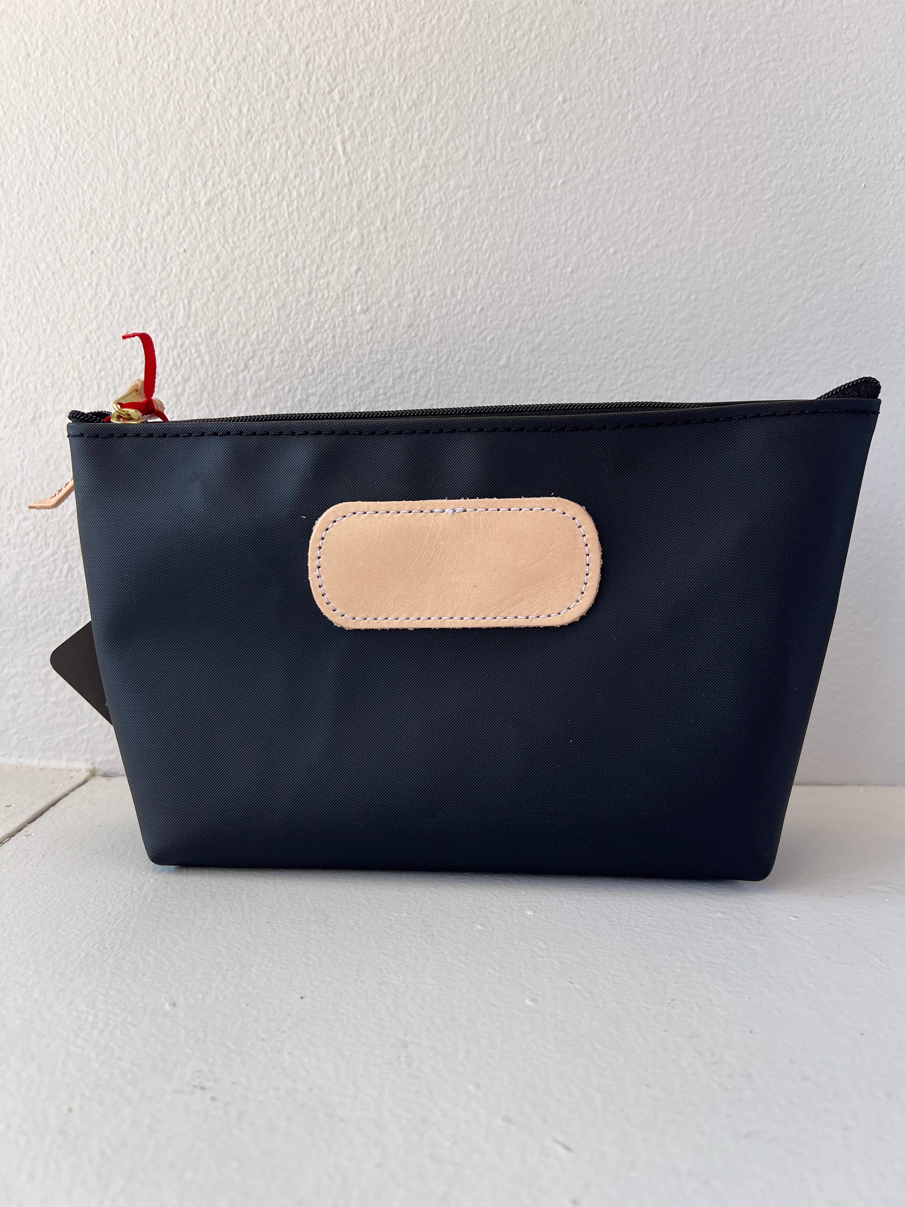 Black pouch with beige patch on a white background