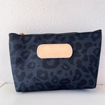 Black leopard print pouch with beige flap on a white background