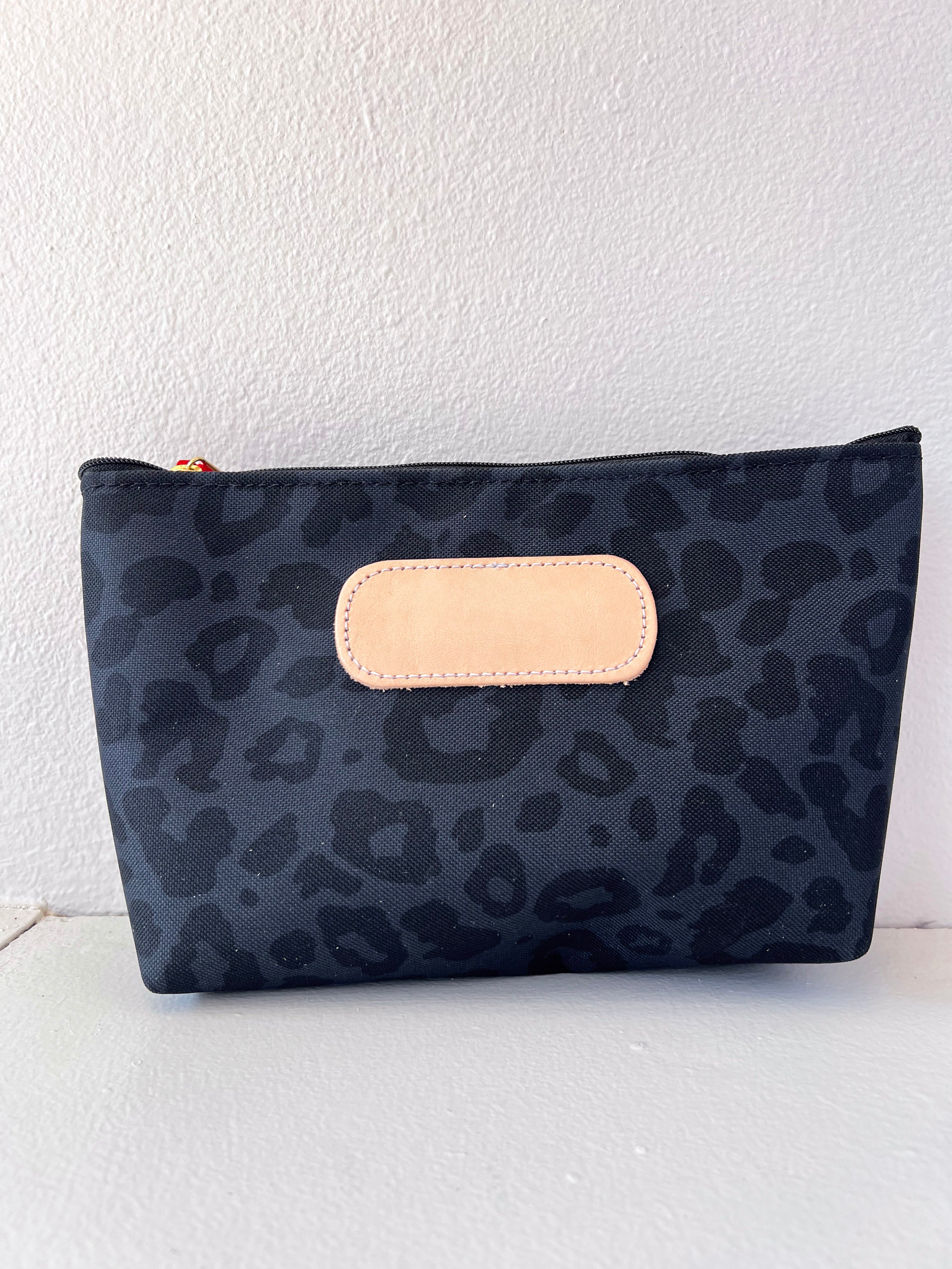 Black leopard print pouch with beige flap on a white background