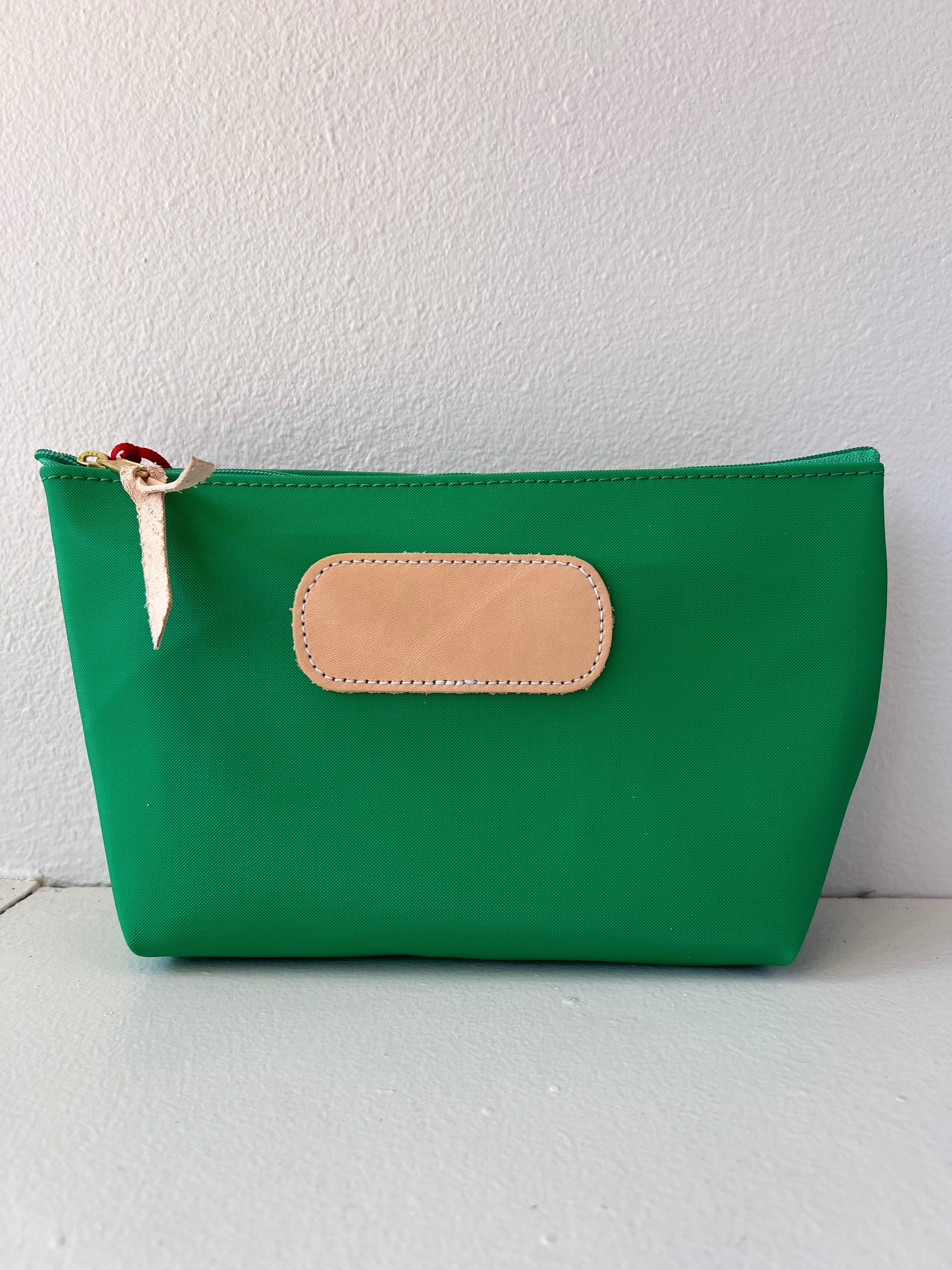 Green pouch with a beige patch on a white background