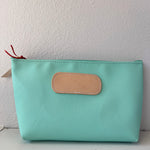 Mint green pouch with a beige patch on a white background
