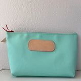 Mint green pouch with a beige patch on a white background