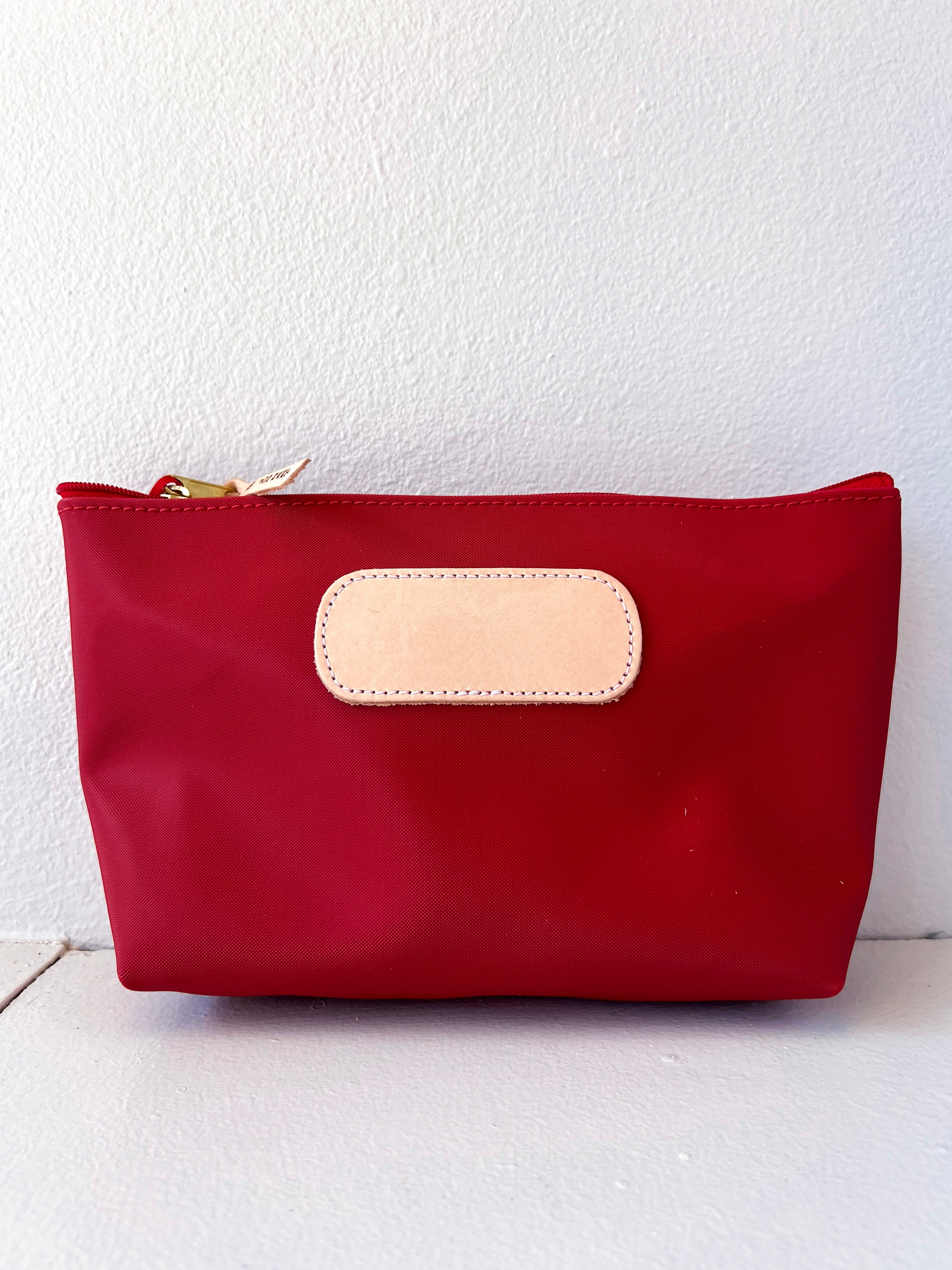 Red pouch with a beige patch on a white background