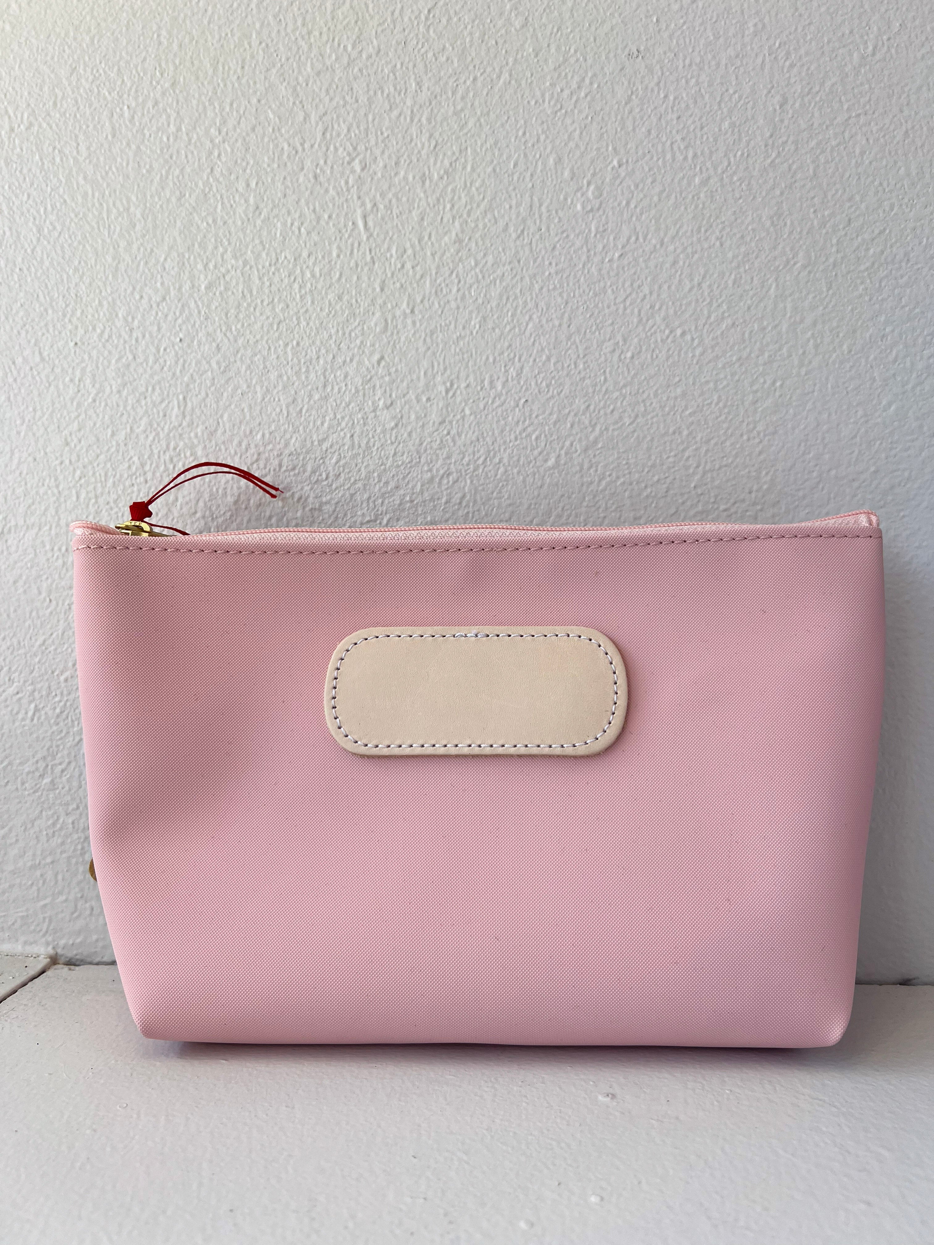Pink pouch with a beige patch on a white background
