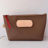 Brown pouch with a red zipper on a white background