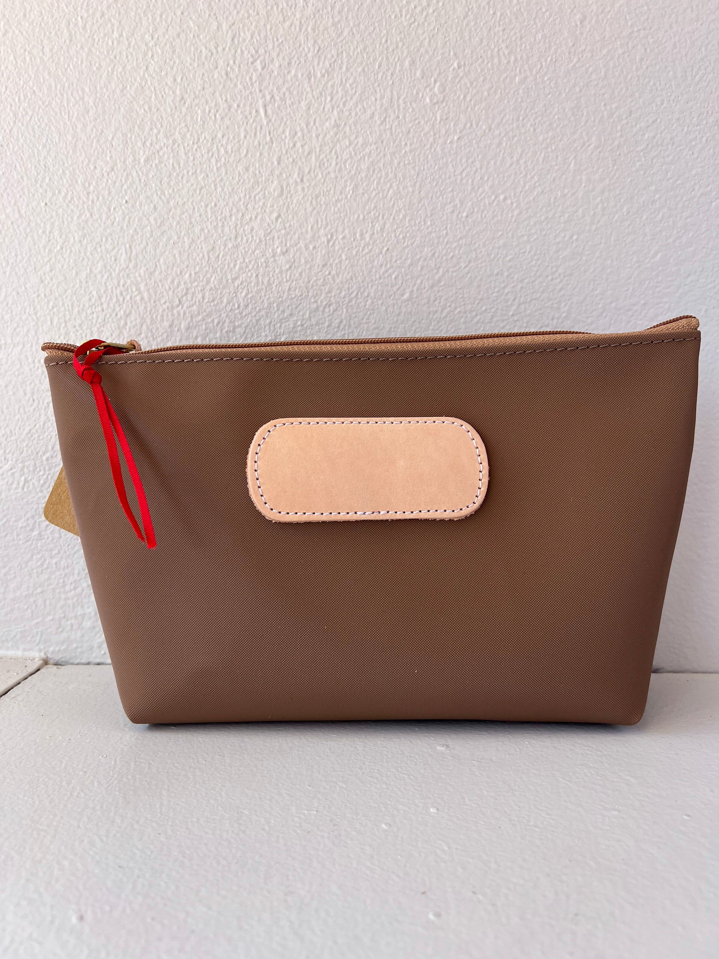 Brown pouch with a red zipper on a white background