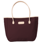 Maroon tote bag with beige handles and trim on a transparent background