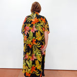 Person wearing a colorful floral dress with a black background