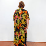 Person wearing a colorful floral dress with a black background
