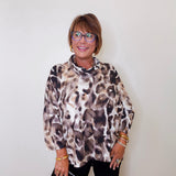 A woman wearing a Joseph ribkoff cowl neck leopard print pullover sweater in front of a white wall. 
