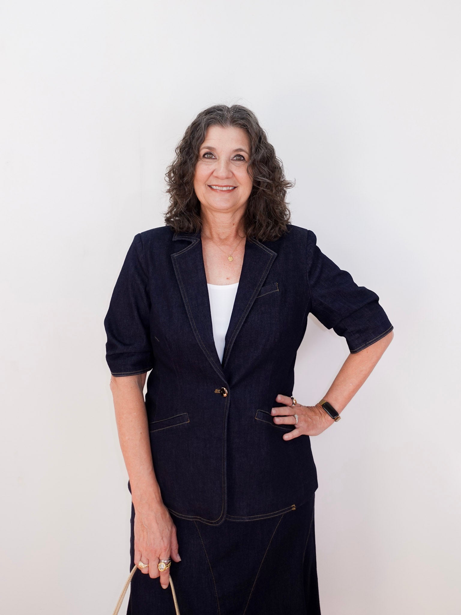 Woman wearing a dark blue suit against a white background