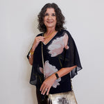 Woman holding a metallic handbag against a plain background